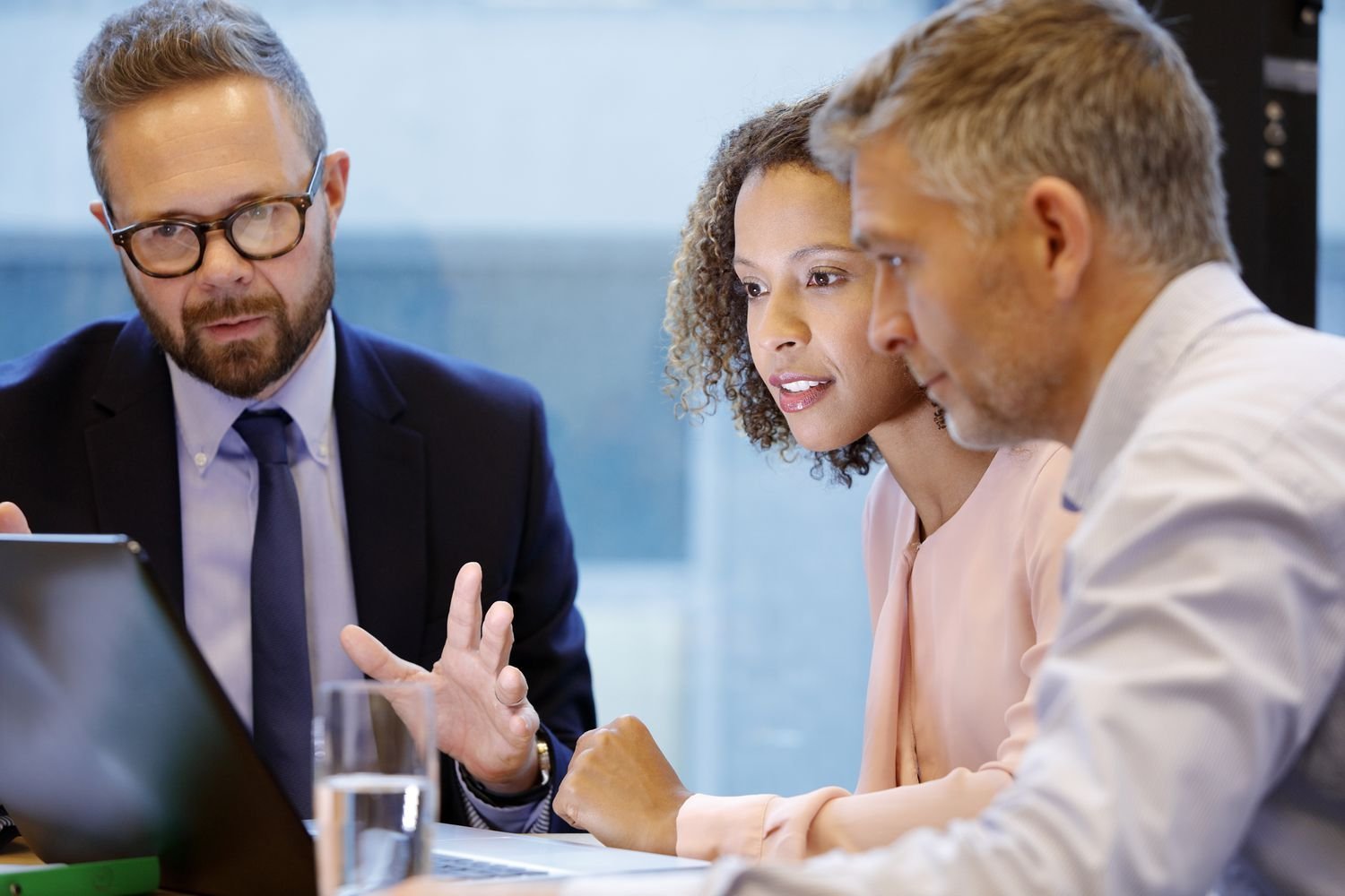Two professionals discussing documents in a bright, modern meeting room
